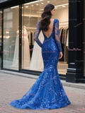 Woman wearing a blue sequin dress in front of a store window.