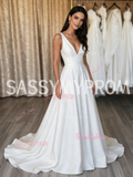 Bride wearing a simple satin V-neck A-line dress in a modern art gallery wedding.