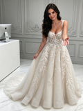 Ivory tulle A-line wedding dress with lace appliqués, sweetheart corset bodice and spaghetti straps, full front view