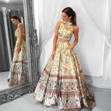 Woman wearing floral crop top and long matching skirt standing beside ornate mirror | PicSEO 1787445886652