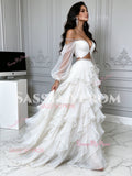 Side view of a cascading multi-layered white tulle ruffle prom dress with crystal trim and long sheer puff sleeves.